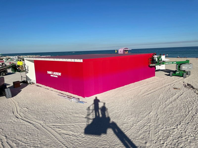 Saint Laurent branded beach pavilion clad in printed gradient panels on Miami Beach during Art Basel