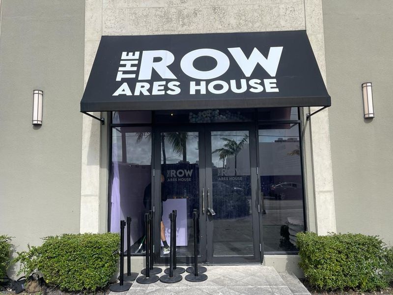 Printed awning and entrance signage reading The Row Ares House