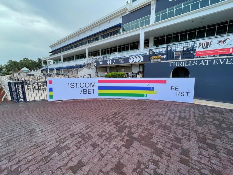 Printed 1ST.COM/BET barrier graphics with colour bar motif at the Gulfstream Park grandstand