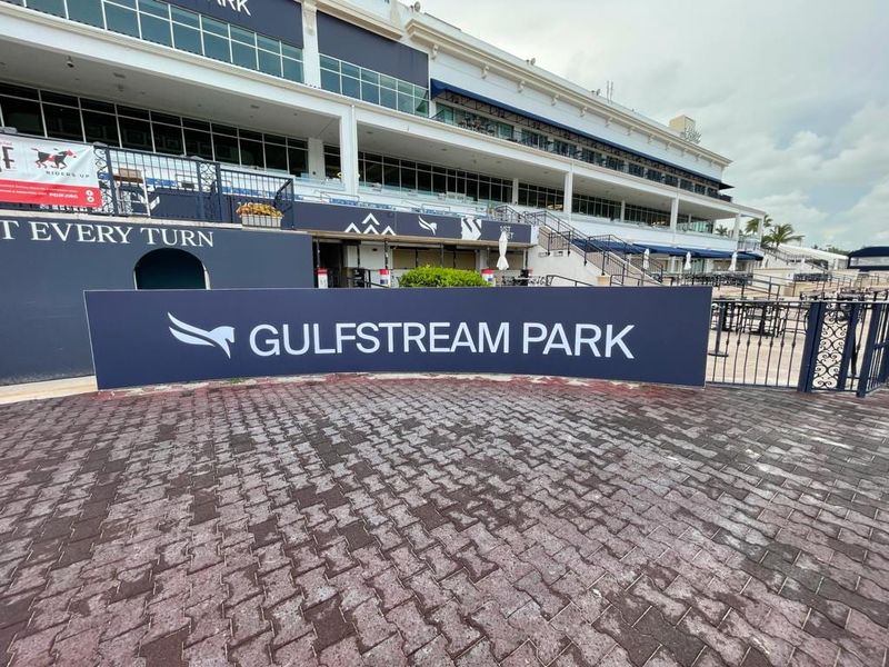 Large-format Gulfstream Park barrier banner running along the paddock in front of the grandstand
